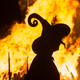 a witch in front of a fire